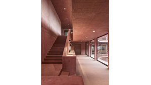 Innovativ gestaltete Büroflächen in der Firmenzentrale von Jäger Bau bieten 140 moderne Arbeitsplätze, die durch fortschrittliche Haustechnik und nachhaltige Materialien wie Holz und rot gefärbten Beton geprägt sind. | © Adolf Bereuter