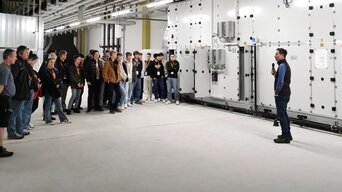 Gruppe von Besucher*innen bei einer technischen Führung in einer großen Anlage