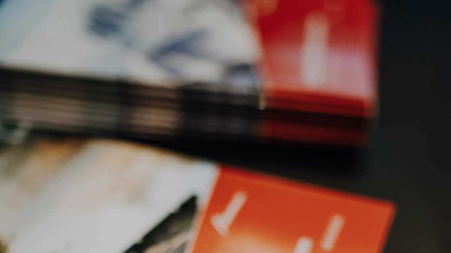 Ein Stapel von Werbeprospekten der Firma bösch, mit dem roten Deckblatt nach oben, auf dem 'Groß und hochtemperatur Wärmepumpen. Individuelle Lösungen für große Leistung.' steht.