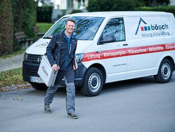 Mitarbeiter von bösch mit Werkzeugkoffer vor dem Servicefahrzeug – Außendienst mit Technik, Verantwortung und Kundennähe