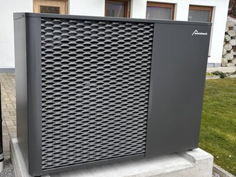 Außenaufgestellte MOZART15 Propan Wärmepumpe von bösch auf Betonfundament neben einem Einfamilienhaus in Zell am See. | © bösch