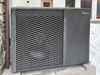 MOZART15 Propan Wärmepumpe von bösch im Winterbetrieb neben einem Einfamilienhaus, teilweise von Schnee umgeben. | © bösch