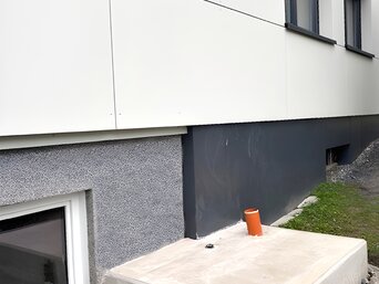 Betonsockel für Luft-Wasser-Wärmepumpe vor Mehrfamilienhaus in Uttendorf – Vorbereitung für Heizungsmodernisierung mit bösch MOZART 20 AC | © Walter Bösch GmbH & Co KG