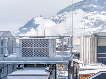 Adiabate Kühleinheiten des Sustainable Hall Conditioning Systems auf dem Dach der Senoplast-Produktionshalle in Piesendorf, umgeben von winterlicher Landschaft