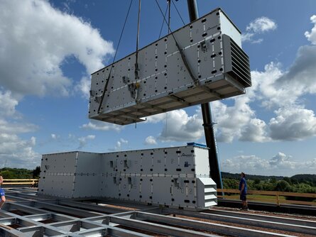Kran hebt ein bösch Lüftungsgerät auf das Dach des TEST-FUCHS Aerospace Campus in Groß-Siegharts.