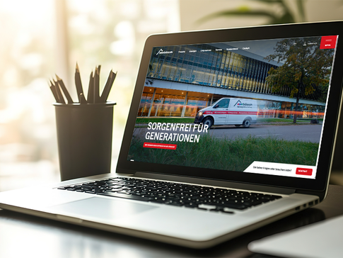 Laptop auf einem Schreibtisch zeigt die www.boesch.at mit dem Slogan „Sorgenfrei für Generationen“ auf dem Bildschirm, im Hintergrund ist ein bösch-Firmenfahrzeug vor einem modernen Gebäude zu sehen.