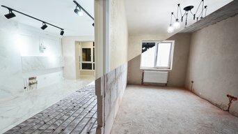 Geteilter Innenraum zeigt eine Wohnung vor und nach der Sanierung – links mit moderner Fußbodenheizung und fertigem Ausbau, rechts im unsanierten Zustand als Beispiel für förderfähige Sanierungsmaßnahmen