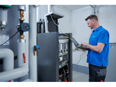 Techniker vom bösch Kundendienst überprüft System eines Kunden mit einem Laptop